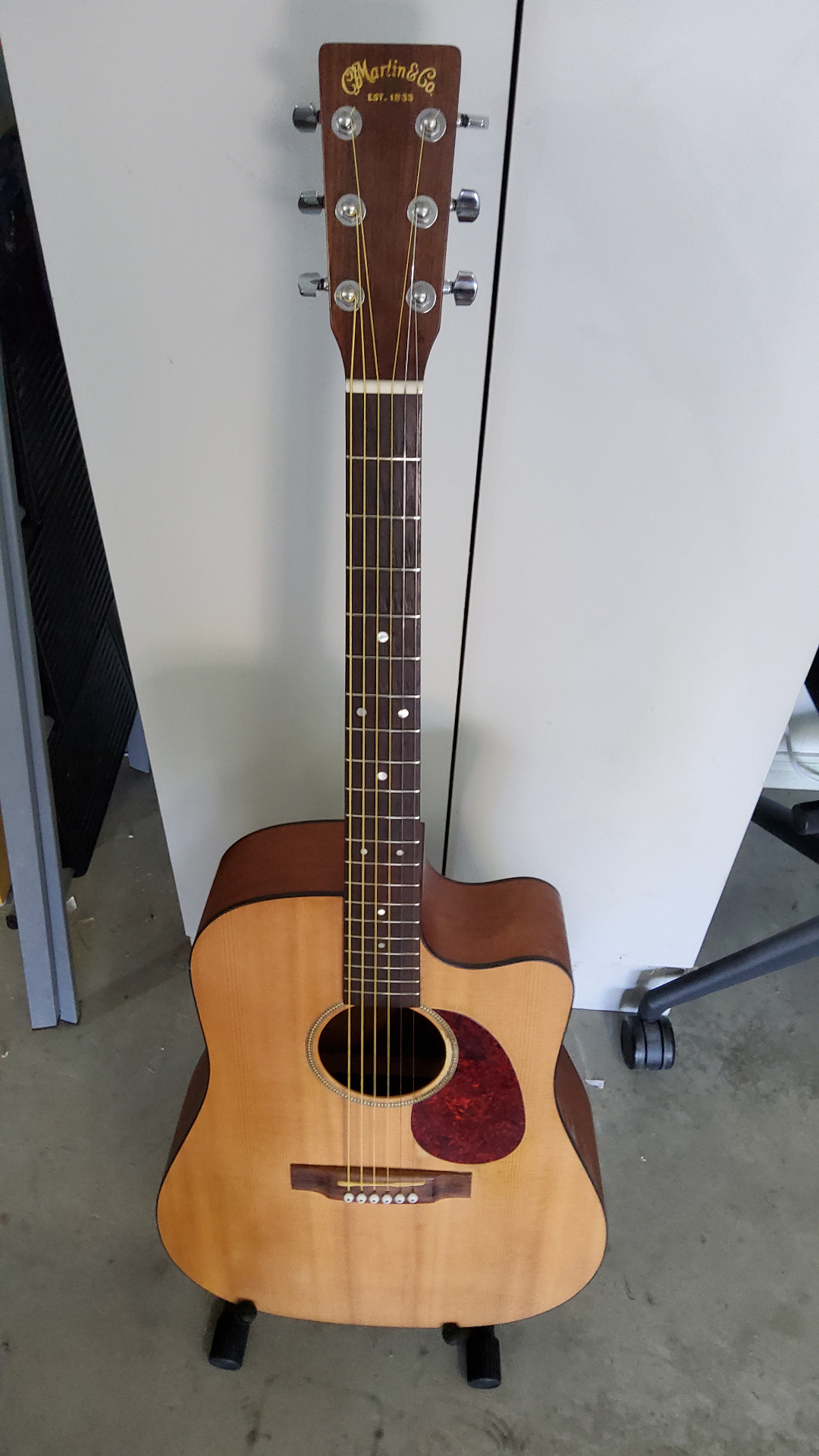 Martin acoustic guitar fully restrung and set up after fret work, standing on a guitar stand